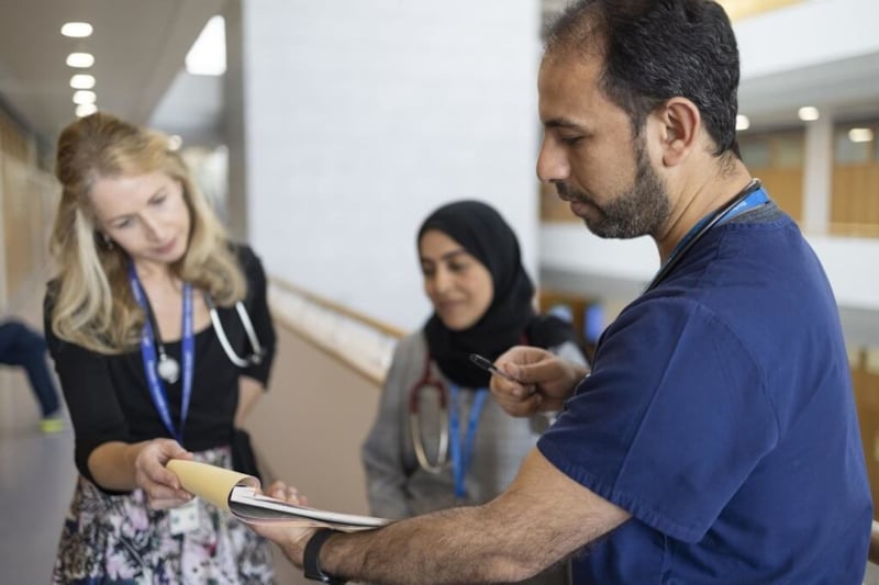 3 doctors talking in a hospital corridor